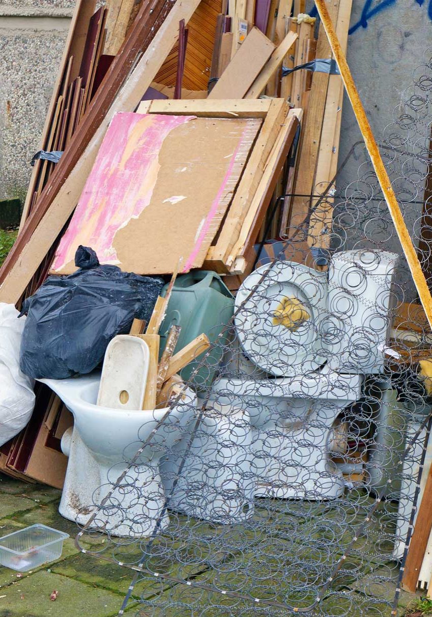 Old broken furniture, old ceramic toilets and microwave at the garbage dump near the apartment building